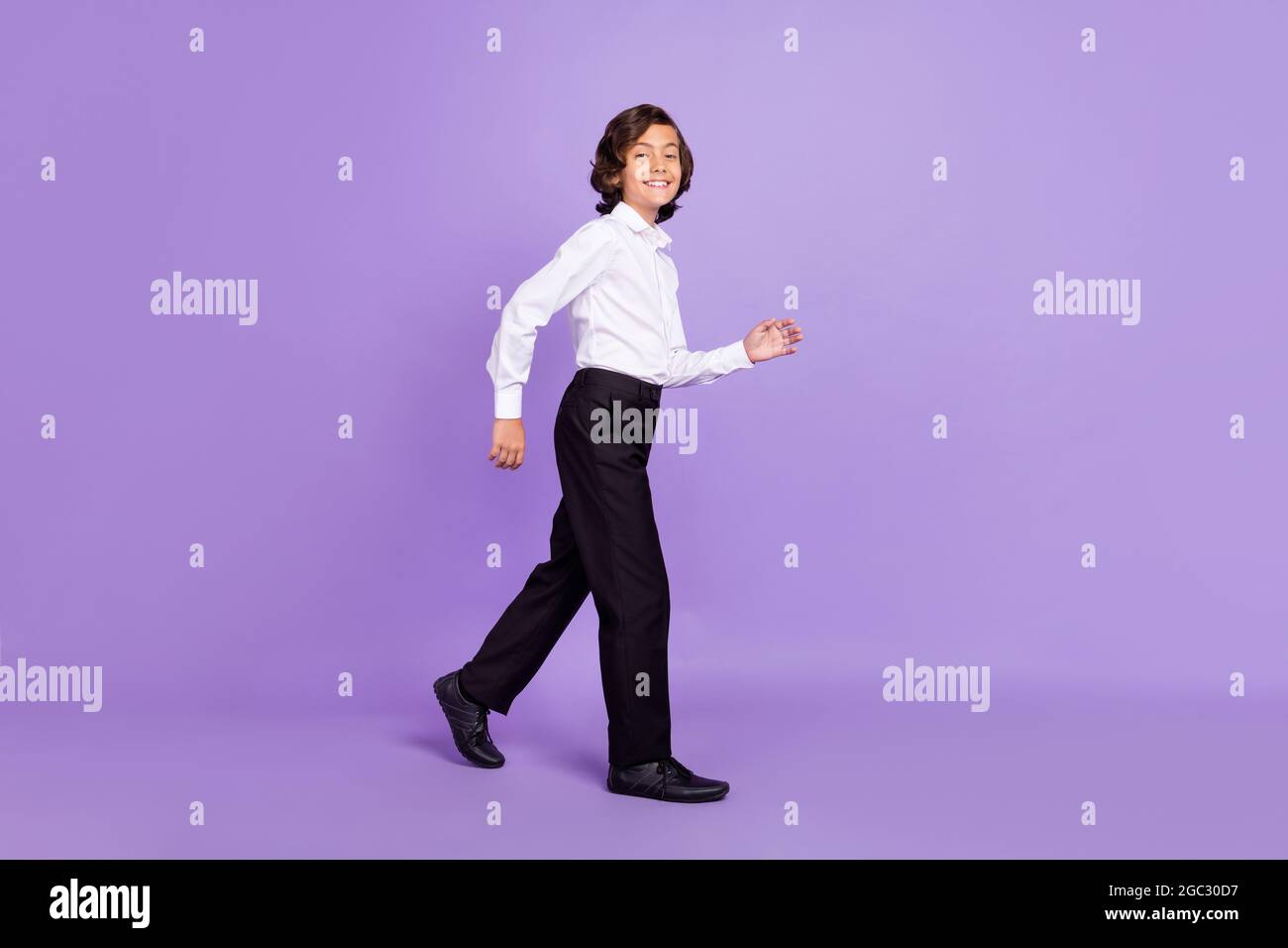 Foto de perfil largo de funky little morenet niño ir ropa de vestir  pantalón sneakers aisladas sobre fondo de color púrpura Fotografía de stock  - Alamy