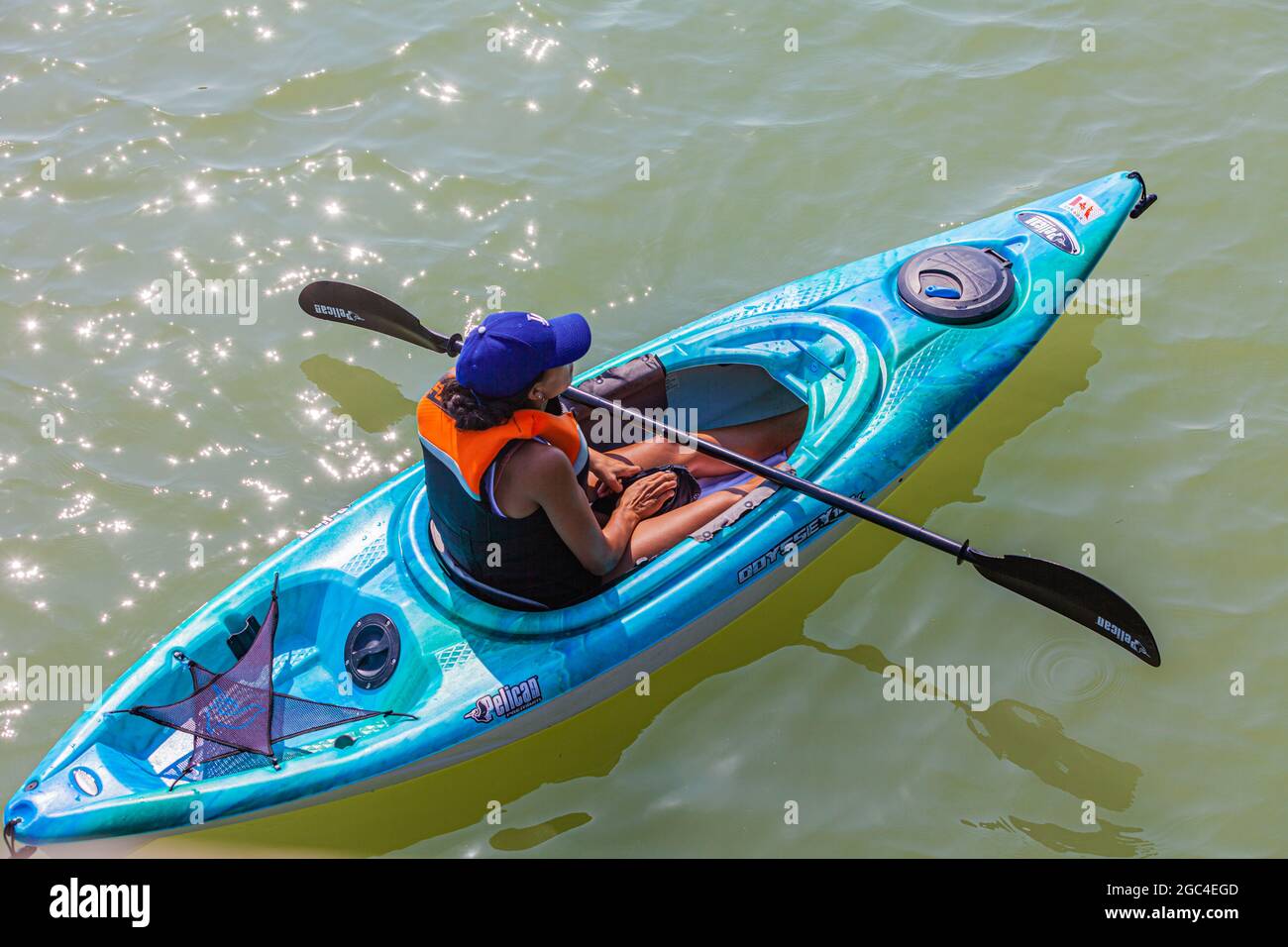 Joven mujer kayak haciendo una pausa para devolver su teléfono móvil a su bolso mientras remar a lo largo de la costa de Steveston en British Columbia Canadá Foto de stock