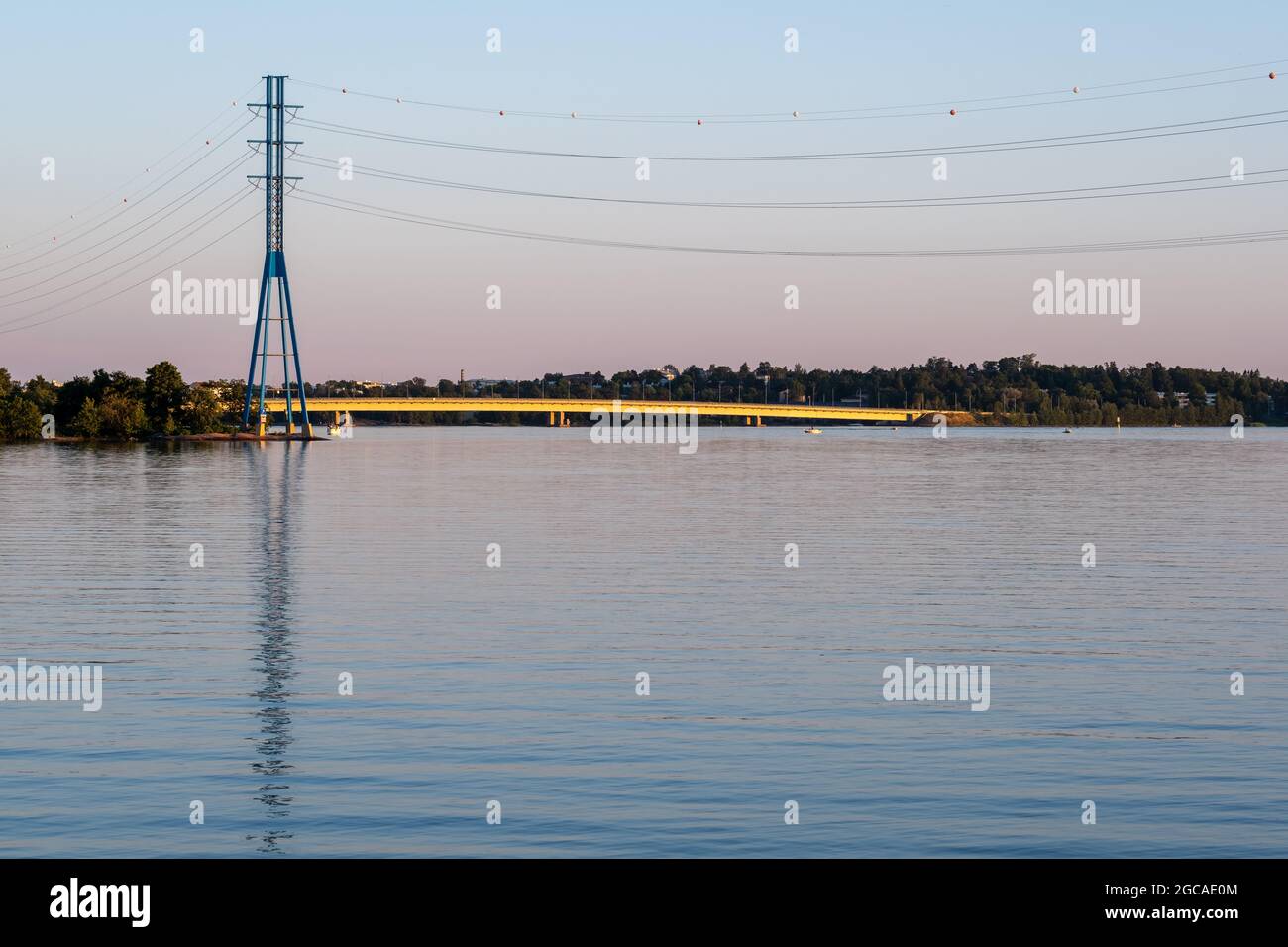 Helsinki / FINLANDIA - 29 DE JUNIO de 2021: Un pilón moderno de electricidad de alta tensión en la orilla durante la puesta del sol. Foto de stock