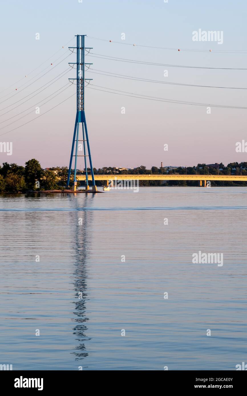 Helsinki / FINLANDIA - 29 DE JUNIO de 2021: Un pilón moderno de electricidad de alta tensión en la orilla durante la puesta del sol. Foto de stock