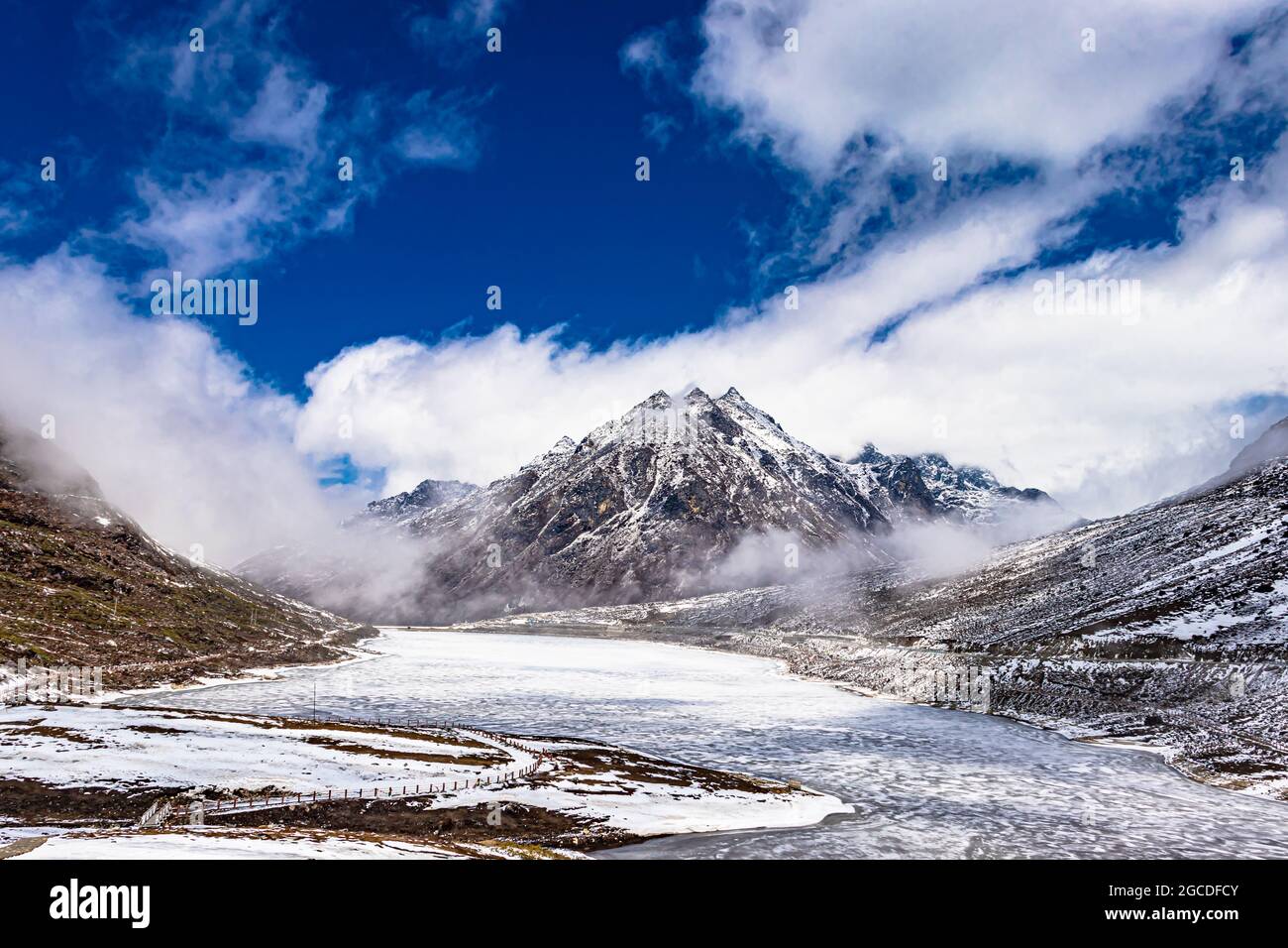 montañas nevadas con lago congelado y cielo azul brillante por la mañana desde ángulo plano se toma una imagen en sela tawang arunachal pradesh india. Foto de stock