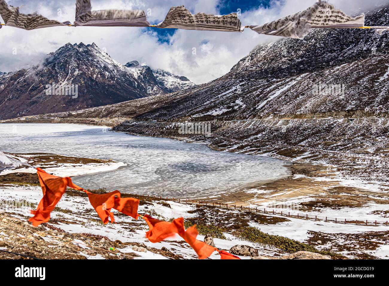 montaña nevada con cielo dramático a través del marco de las banderas del budismo borroso en el día de la imagen se toma en el paso de sela tawang arunachal pradesh india. Foto de stock
