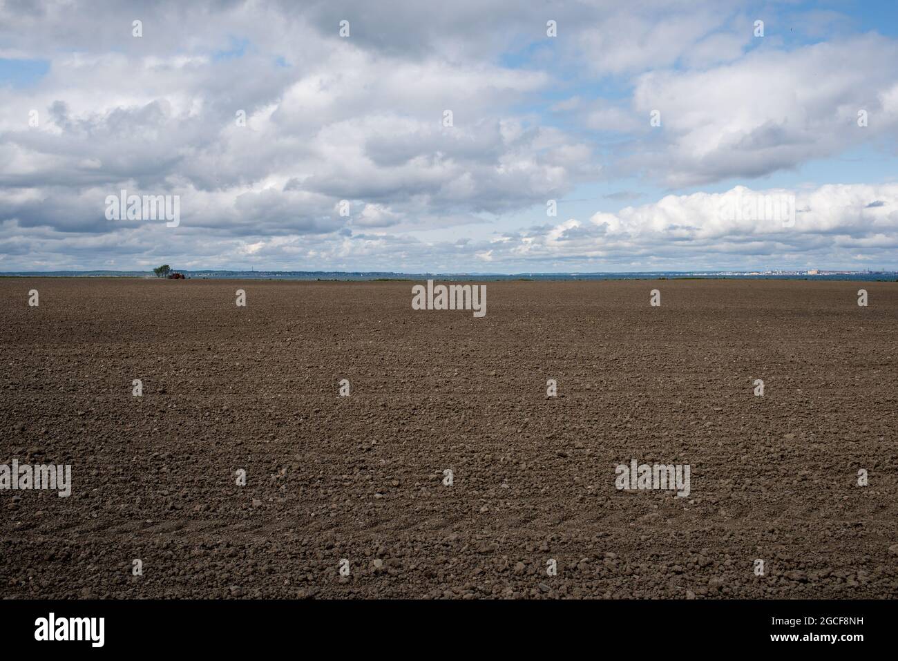 Tierras agrícolas en la isla Ven en Suecia con suelo fresco y tractor en el horizonte Foto de stock