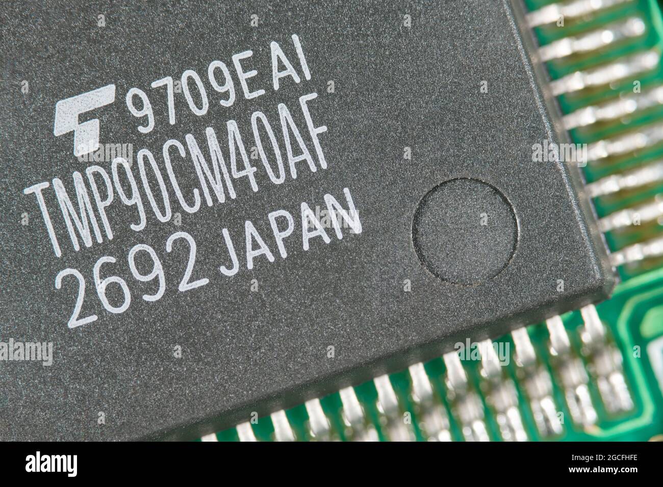 Macro foto de cerca de lo que se cree que es un microcontrolador CMOS de 8 bits producido por Toshiba fabricado en Japón. Para la escasez de microchip, pequeñas piezas electrónicas Foto de stock