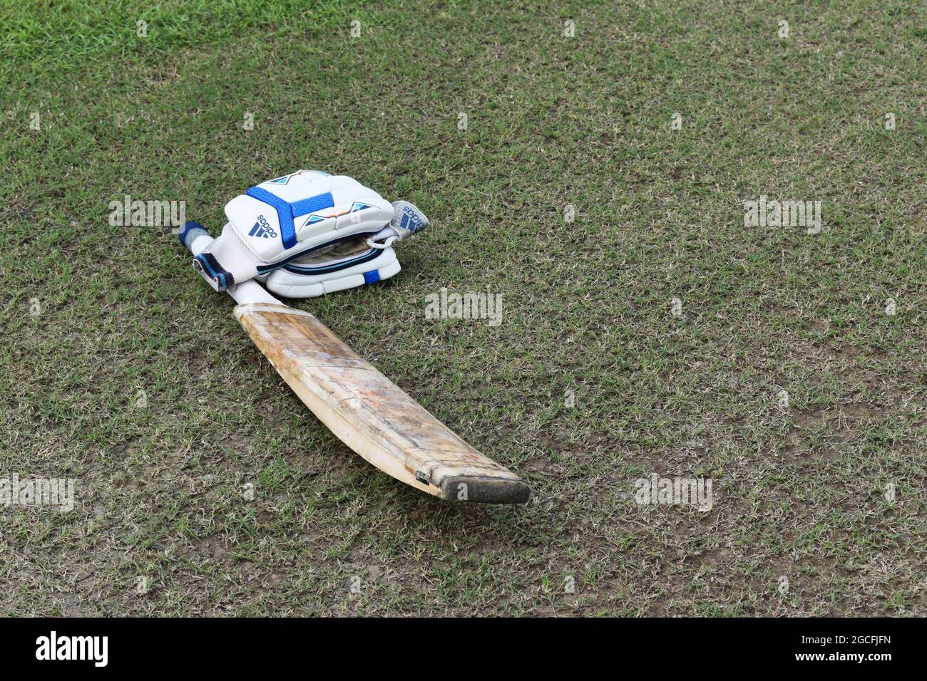 Un bate de críquet y guantes tumbados en el suelo. Sri Lanka. Foto de stock