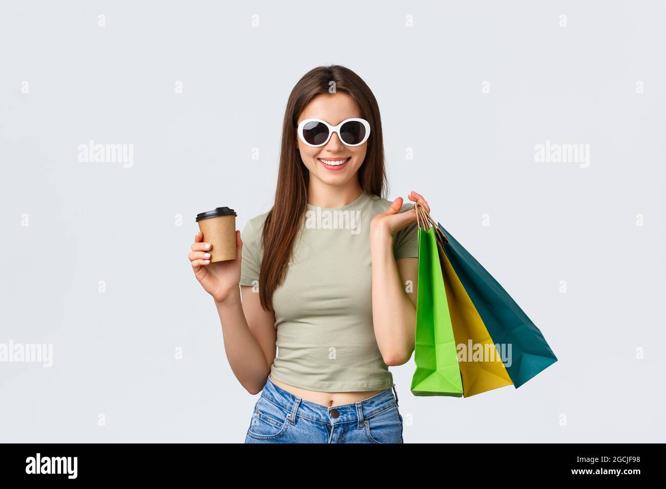 Centro comercial, estilo de vida, turismo y concepto de moda. Mujer elegante  y despreocupada con gafas de sol, tomando café y comprar ropa, sosteniendo  para llevar Fotografía de stock - Alamy