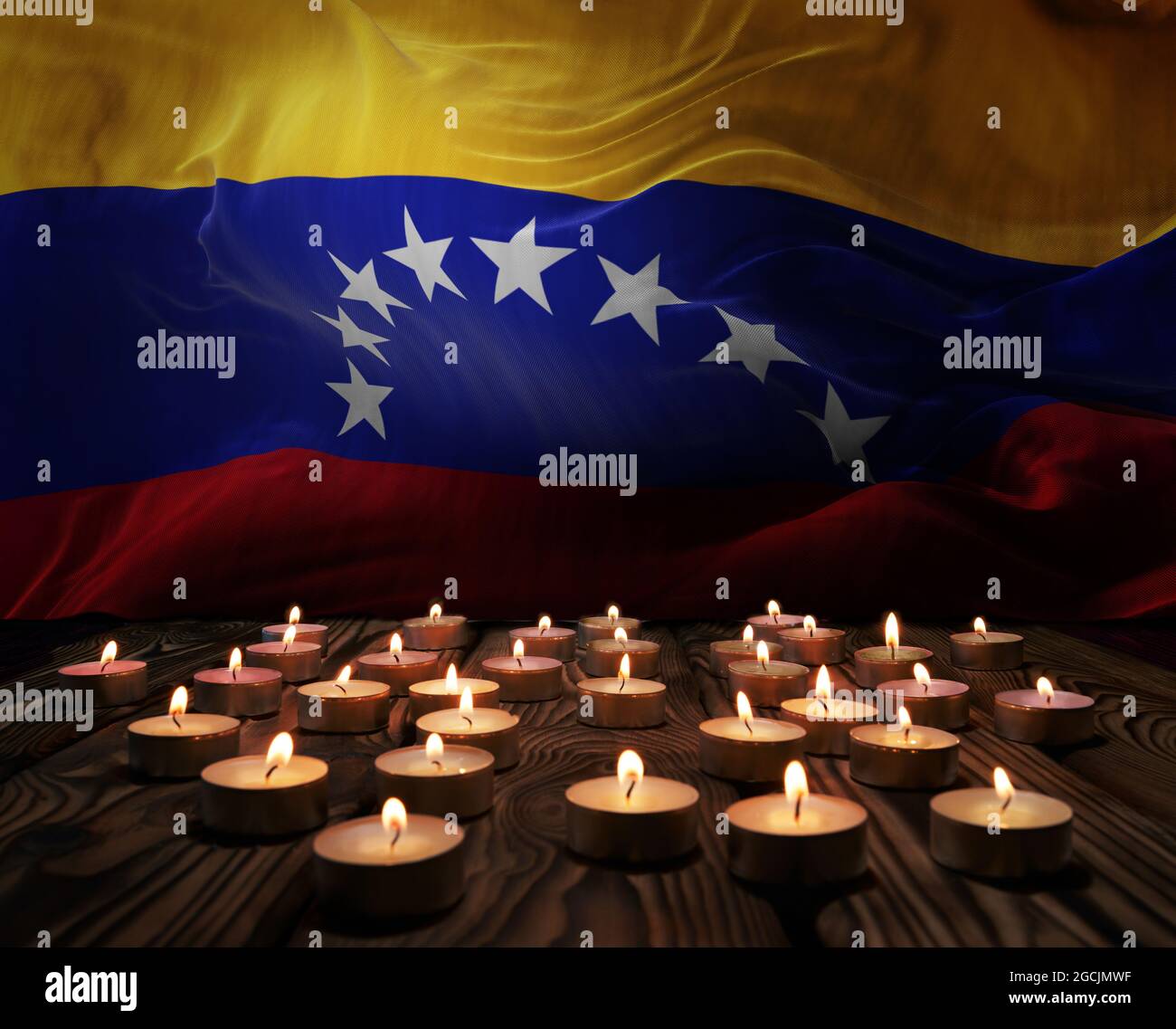 Velas de luto encendidas sobre la bandera nacional de Venezuela de