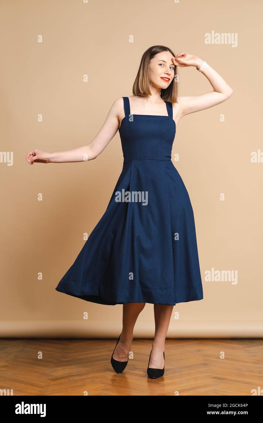 Hermosa mujer bonita cara brillante cuidado de la cara rubia oscuro cabello  vestir ropa corta azul vestido sobre fondo beige Fotografía de stock - Alamy