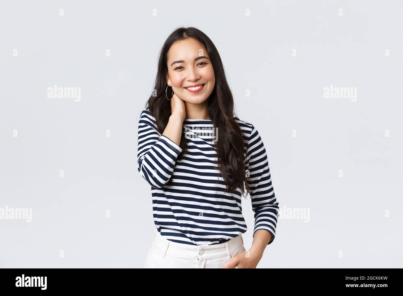 Estilo de vida, emociones de la gente y concepto casual. Alegre hermosa  mujer asiática en ropa elegante informal, tocar el cuello sonriendo y  sonriendo, teniendo pequeño Fotografía de stock - Alamy
