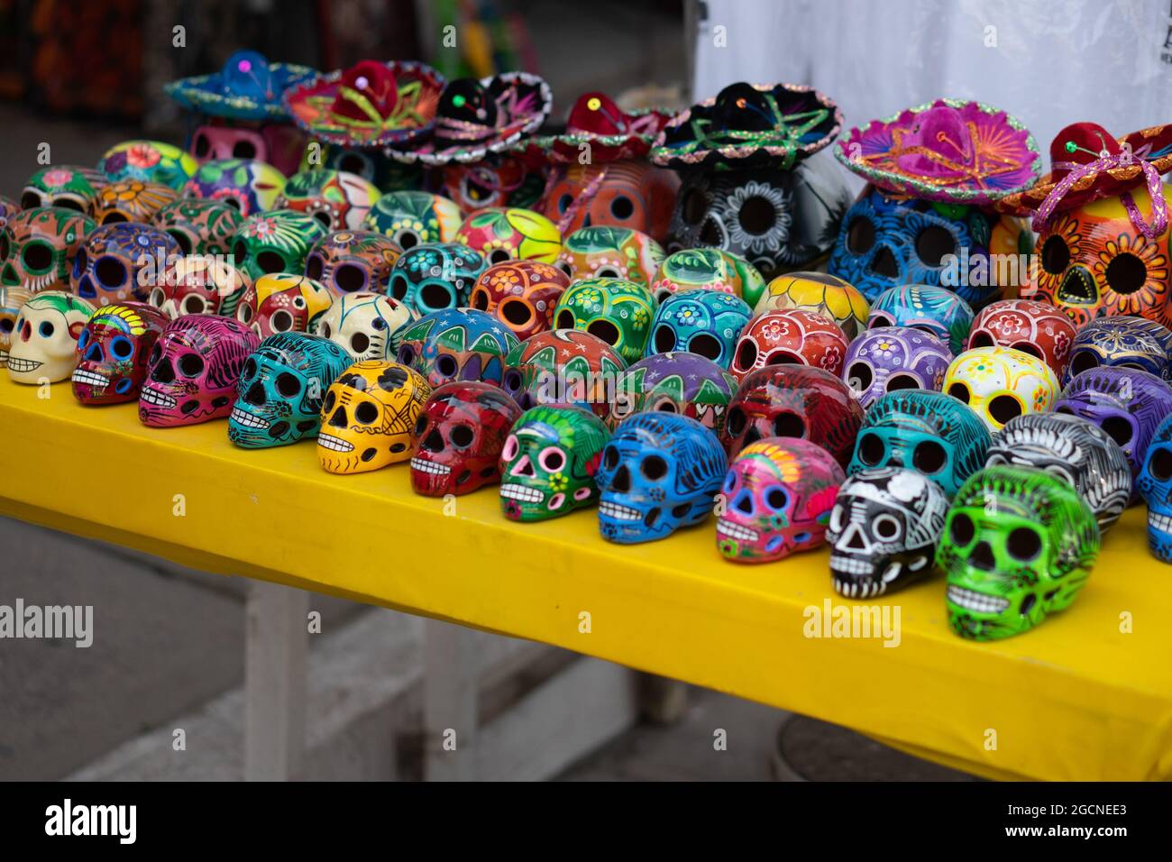 Gran cantidad de calaveras decorativas coloridas en una mesa para la venta  Fotografía de stock - Alamy