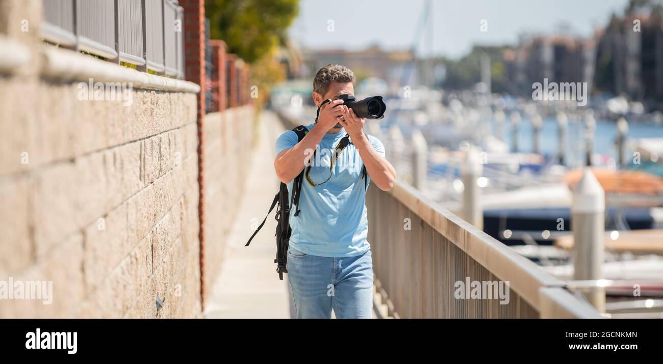 Fotógrafo de viajes independiente hombre tomar fotografías con cámara durante las vacaciones de verano, la fotografía Foto de stock