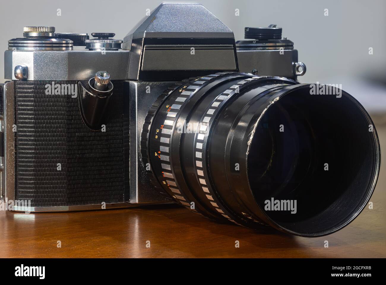 Leipzig, Saxonia, Alemania - 2 de octubre de 2020: Antigua cámara fotográfica Praktica Nova rayada, con 150mm lentes Meyer Optik sobre una mesa rústica de madera. E Foto de stock