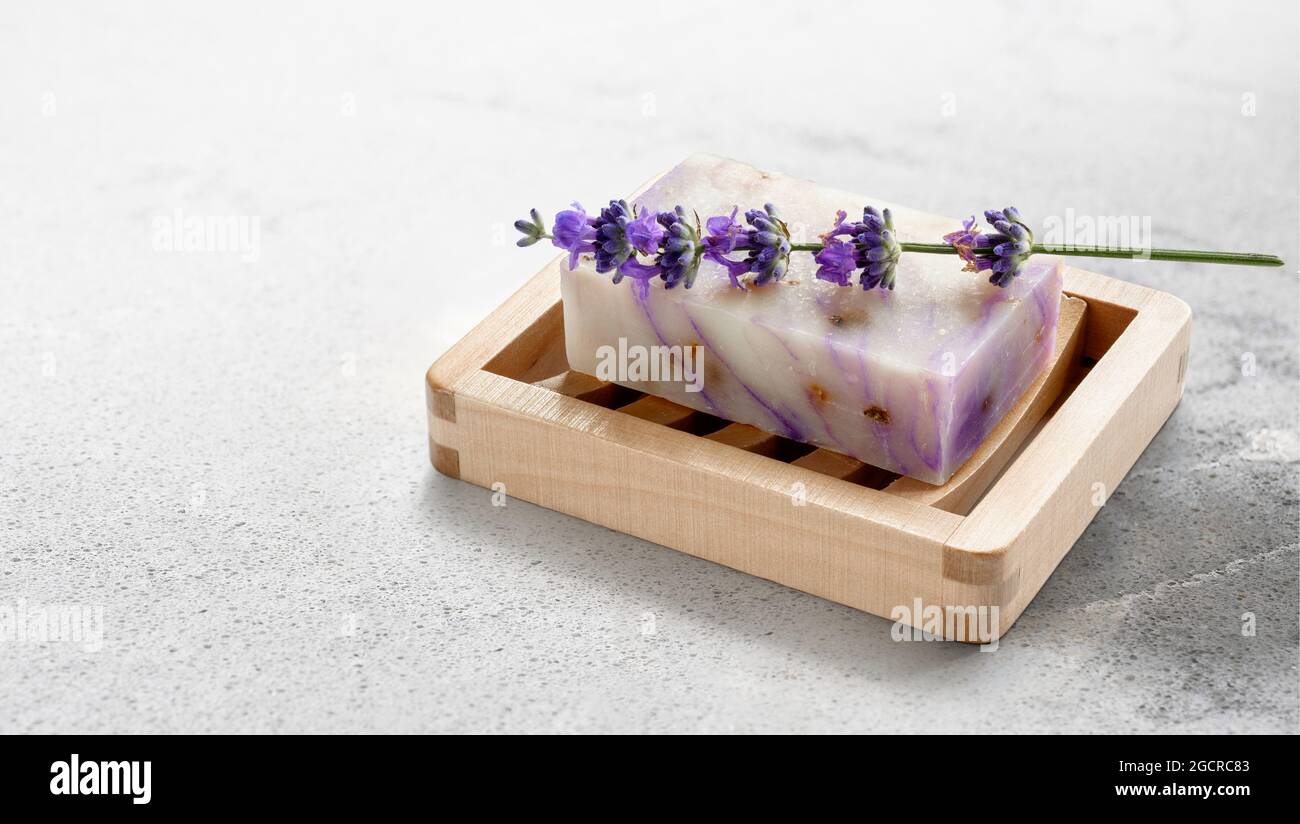 Jabón de lavanda casero natural con flores de lavanda sobre un plato de  jabón de madera sobre fondo de mesa de piedra de mármol. Espacio de copia  Fotografía de stock - Alamy