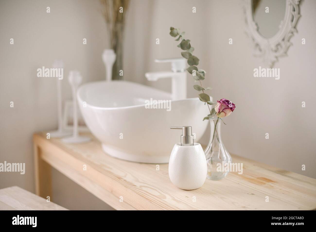 Baño moderno. Lavabo, jabón líquido, jarrón con flores secas sobre tocador  de madera Fotografía de stock - Alamy