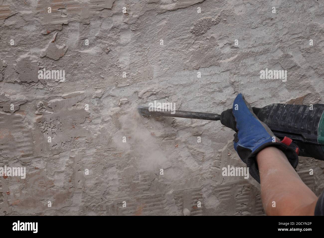 Trabajador quitar, demoler las baldosas viejas y el mortero de la pared  usando un martillo eléctrico y un cincel en un cuarto de baño o cocina  Fotografía de stock - Alamy