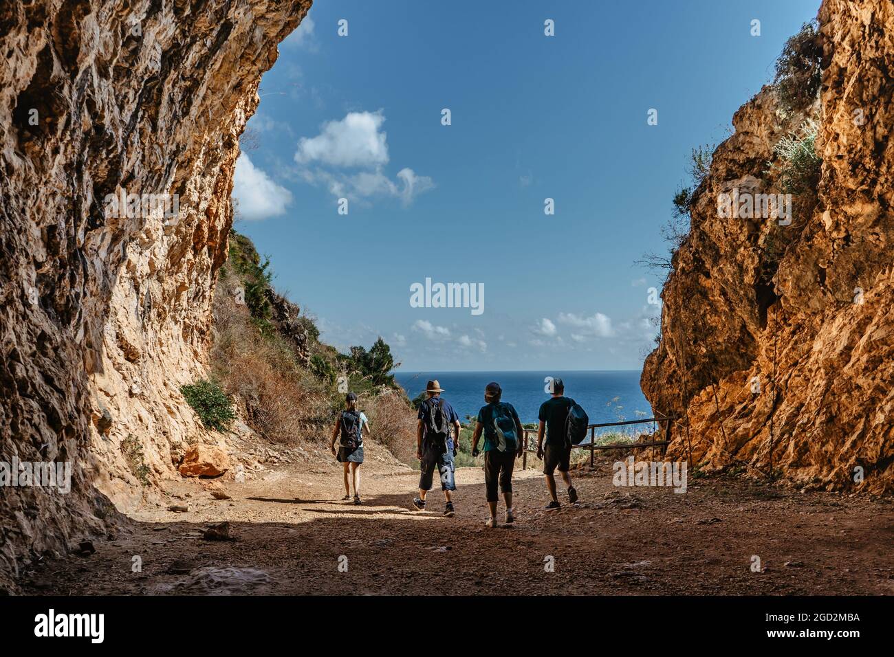 Siluetas de la familia en vacaciones activas back view.Grupo de dos personas mayores y dos adultos trekking en montañas rocosas,Sicilia,Italia.Feliz multi-generación Foto de stock