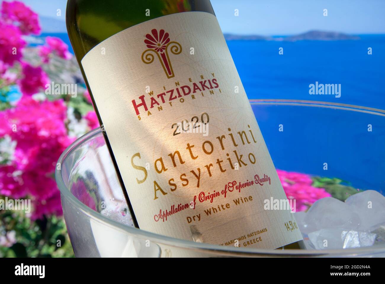 SANTORINI VINO GRIEGO AL AIRE LIBRE Cerrar vista en Hatzidakis Santorini  vino iluminado etiqueta 2020 en botella en frío con buganvillas y mar de  Agean en el fondo Fotografía de stock - Alamy