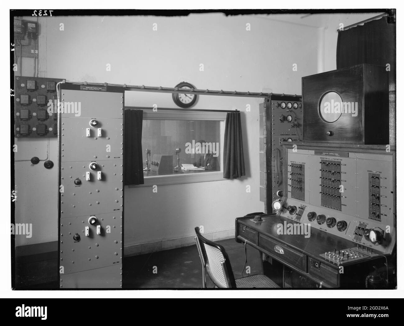 Estudio de radio. Sala de control, mirando al estudio donde un locutor está  emitiendo aprox. Entre 1934 y 1939 Fotografía de stock - Alamy