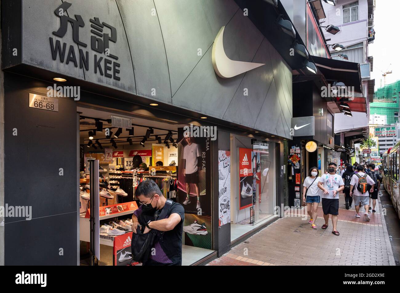 Hong Kong, China. 10th de agosto de 2021. Los peatones pasan por delante de la marca de ropa deportiva multinacional la tienda Nike y su logotipo Hong Kong. (Foto