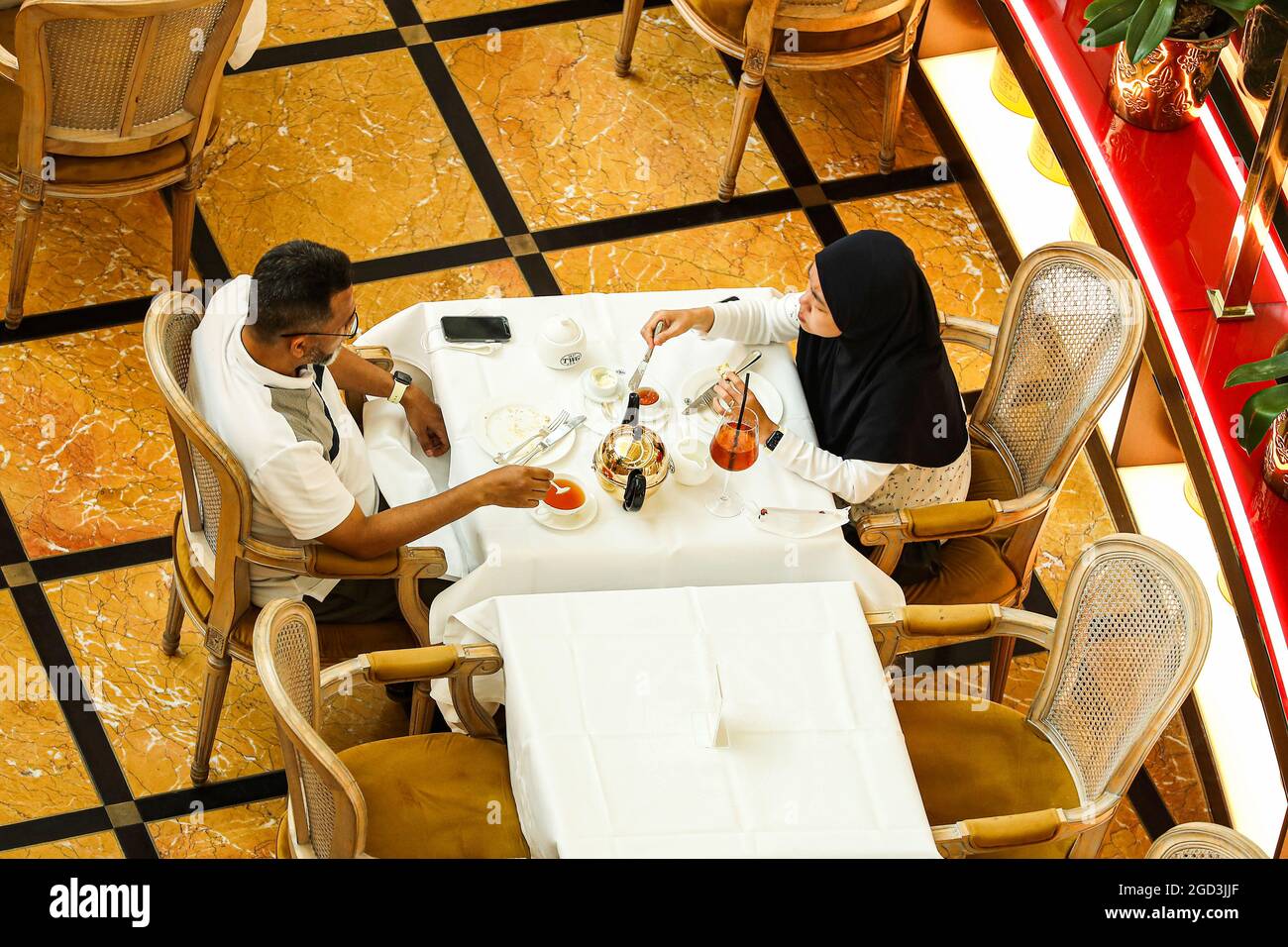 Singapur, Singapur. 10th de agosto de 2021. Una pareja cena en un café en Marina Bay Sands en medio de una pandemia de covid-19.El 70% de la población de Singapur ha sido vacunada totalmente contra covid-19 según datos del Ministerio de Salud. (Foto de Lionel ng/SOPA Images/Sipa USA) Crédito: SIPA USA/Alamy Live News Foto de stock