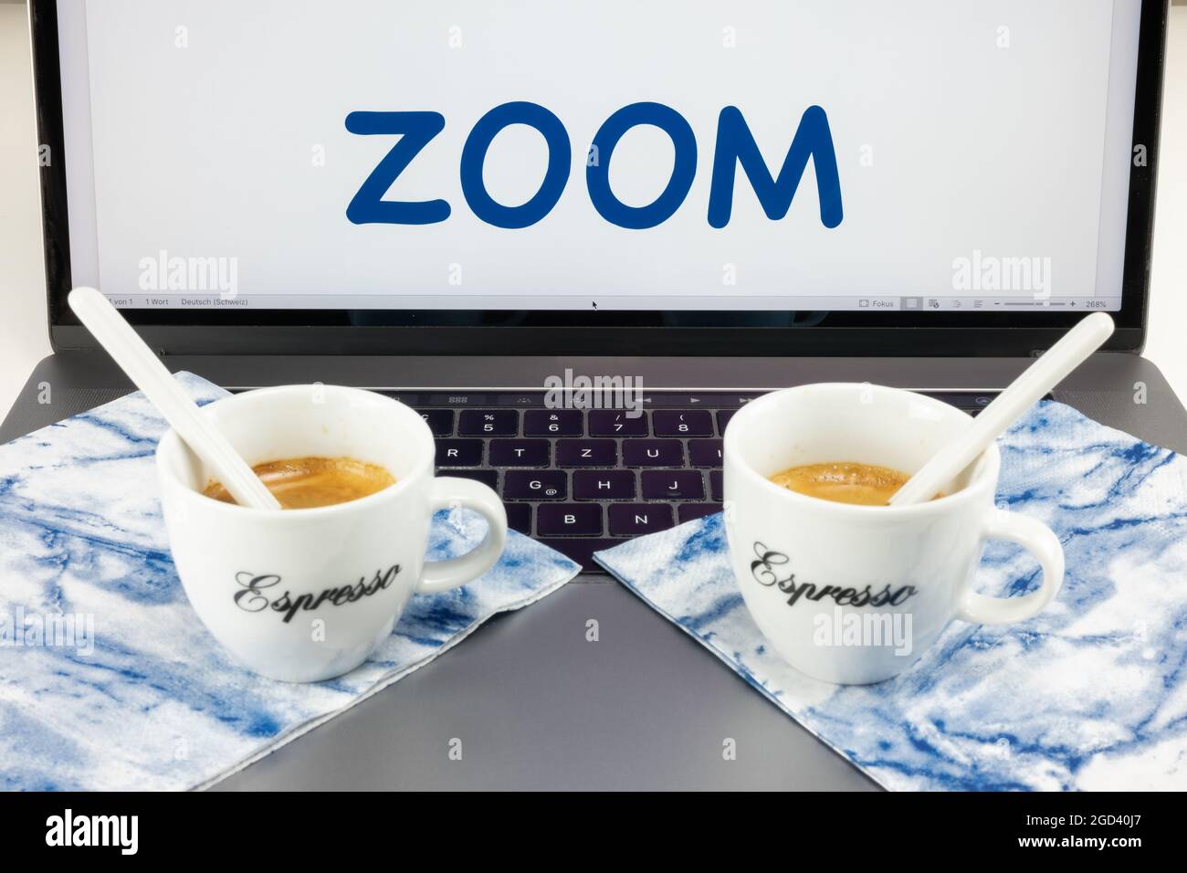Dos tazas de café yacen en un ordenador de escritorio, y pantalla dice Zoom. Concepto de reunión zoom Fotografía de stock - Alamy
