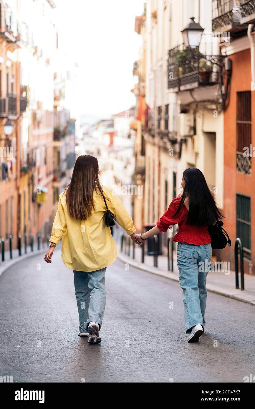 Amigas asiáticas no reconocidas caminando por la ciudad de Madrid y  sujetándose de la mano Fotografía de stock - Alamy