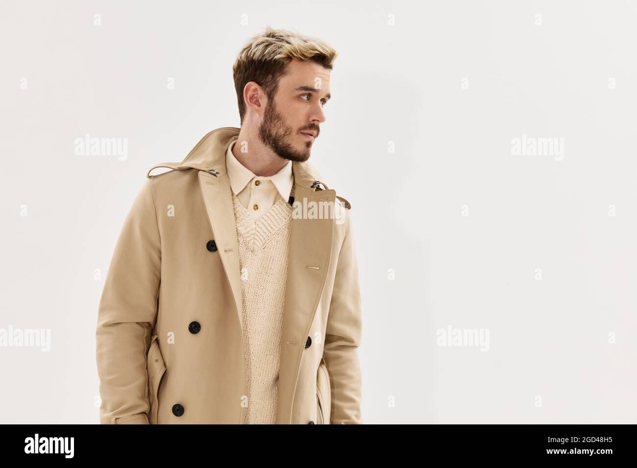 hombre guapo en beige abrigo de moda peinado lado mirada fondo claro  Fotografía de stock - Alamy