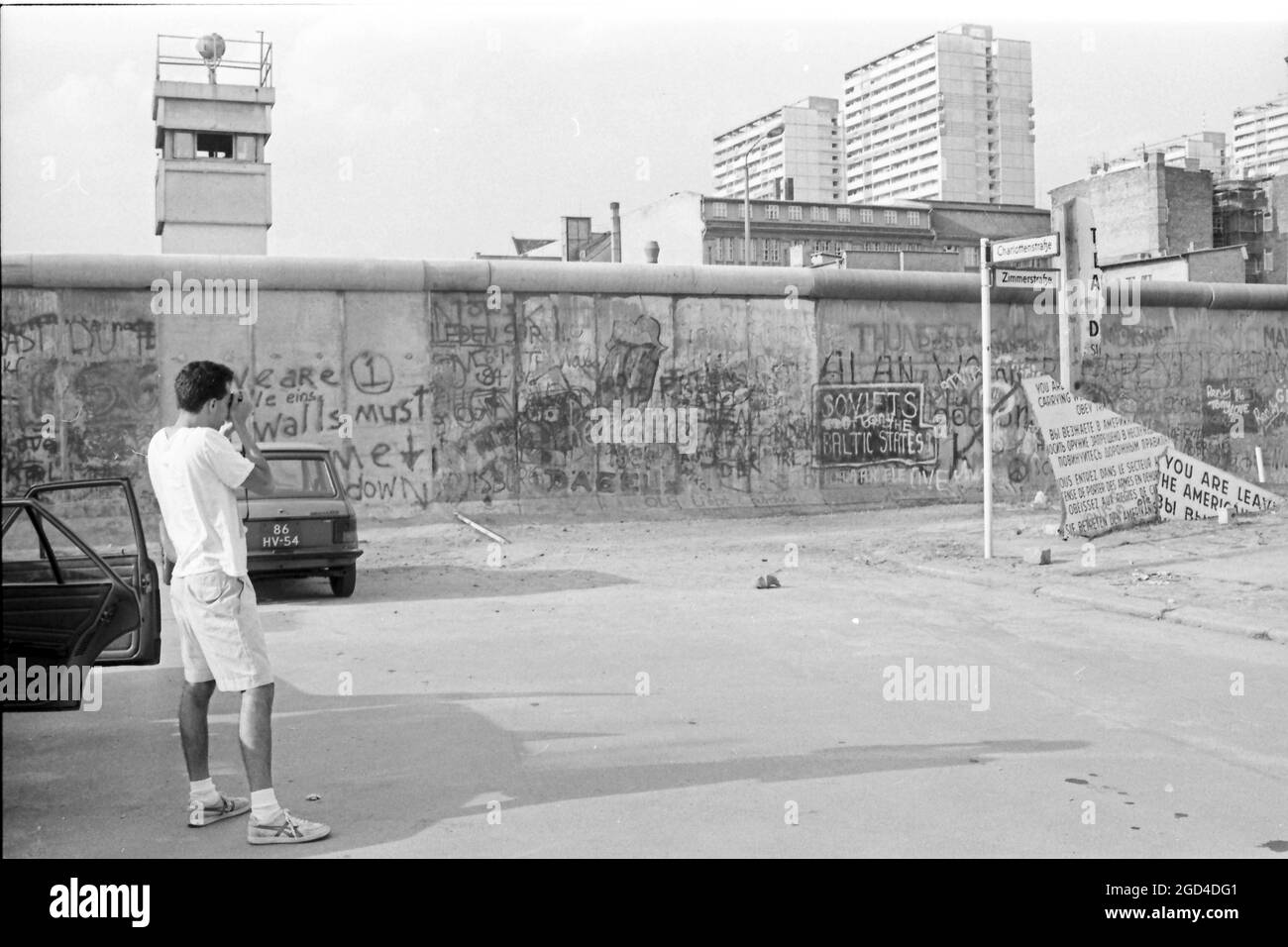 22 de julio de 1986, Berlín: Un hombre toma una foto del Muro de Berlín en el distrito de Kreuzberg. El 13 de agosto de 2021 se cumple el 60th aniversario de la construcción del Muro de Berlín. En el fondo están los edificios altos en Leipziger Straße. Foto: Wolfgang Kumm/dpa Foto de stock