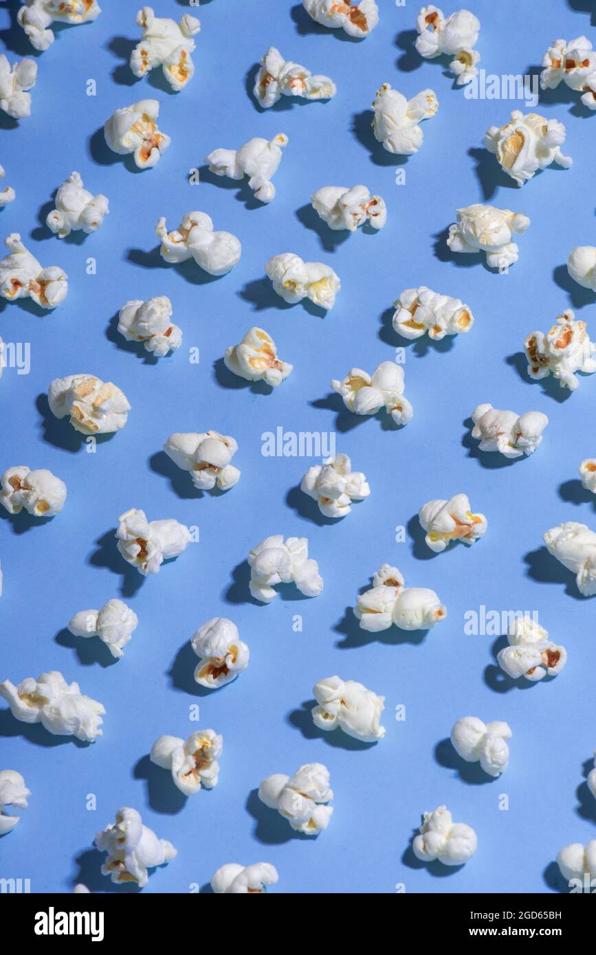 fondo azul sólido con palomitas de maíz blancas alineadas en filas diagonales estilo mínimo, ninguna gente Foto de stock
