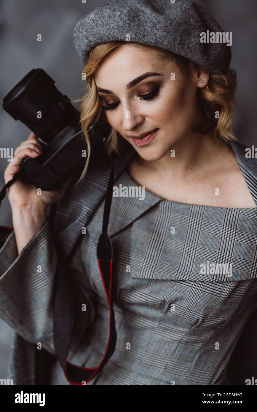 Hermosa mujer fotógrafa con estilo en un traje gris con una cámara en sus  manos en un estudio fotográfico. Enfoque selectivo suave Fotografía de  stock - Alamy