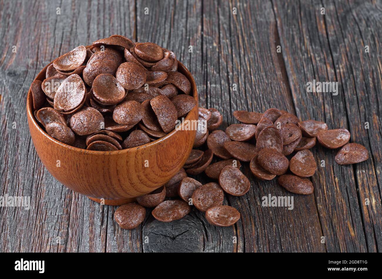 Cereales de chocolate en tazón marrón sobre fondo de madera antiguo Foto de stock