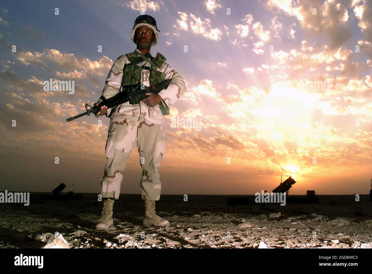 Especialistas del Ejército DE LOS ESTADOS UNIDOS (EE.UU.) Bobby Jenkins, Delta/Battery, Regimiento de Artillería de Defensa Aérea (ADA) del Batallón 3rd-43rd, armado con 5,56mm fusiles M16A2, está parado un reloj de seguridad en el emplazamiento de la Batería de Misiles Patriota MIM-104 ubicado en la Base Aérea Al Udeid (AB), Qatar. (FOTO DE USAF POR MSGT TERRY L. BELVINS 030215-F-5712B-020) Foto de stock