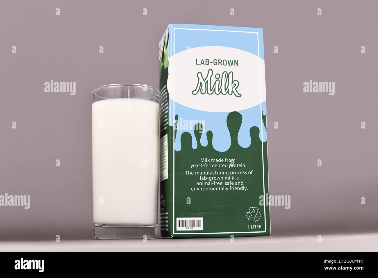 Concepto para la leche cultivada en laboratorio a partir de la producción lechera artificial cultivada utilizando proteínas de leche reproducidas. Cartón con etiqueta y vaso para beber Foto de stock