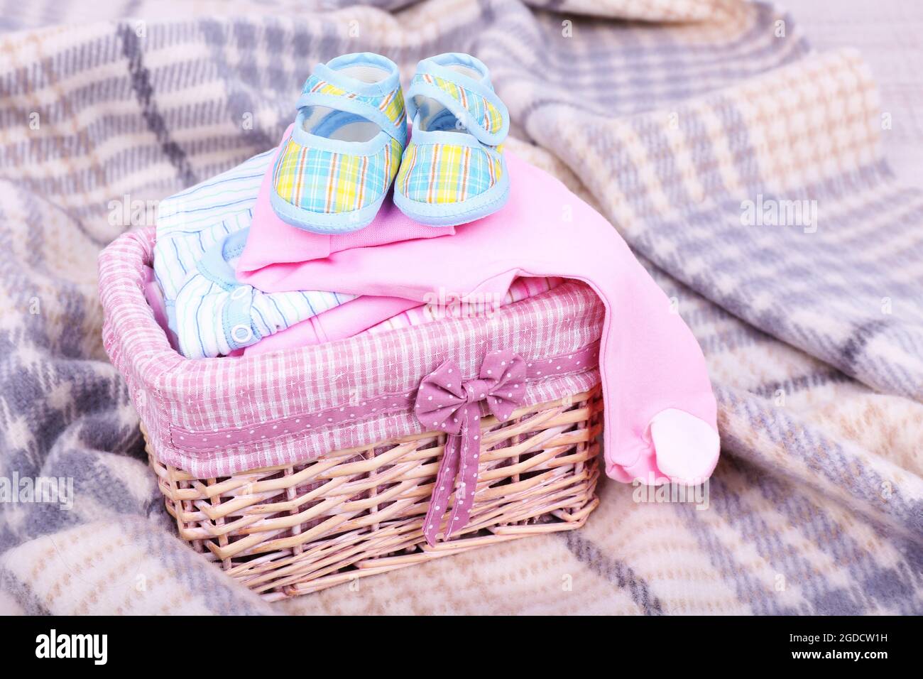 Ropa de bebé en la cesta de cuadros escoceses en la habitación Fotografía  de stock - Alamy
