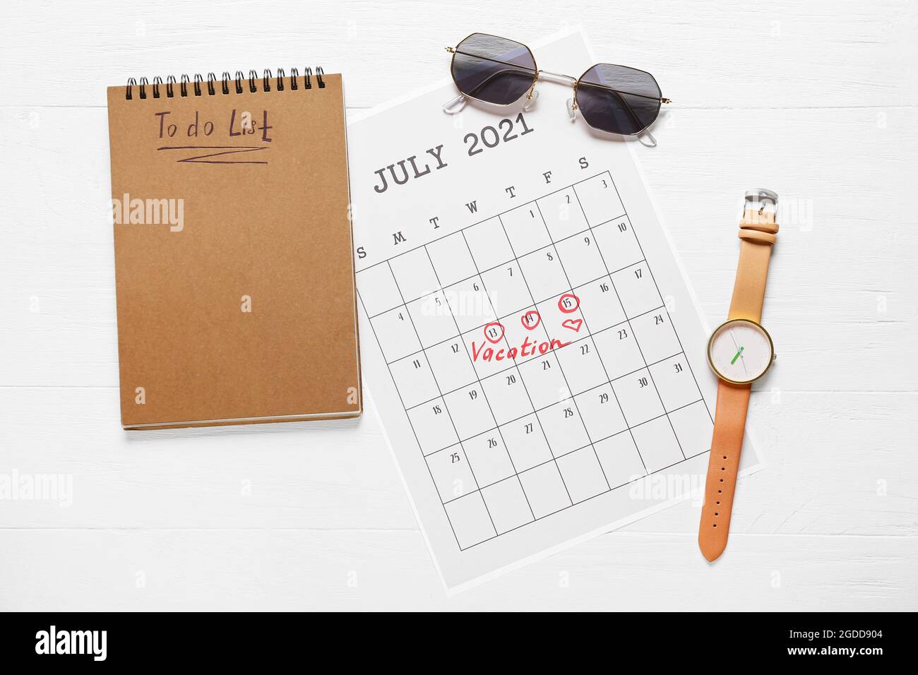Calendario, lista de tareas y accesorios femeninos sobre fondo de madera clara Foto de stock