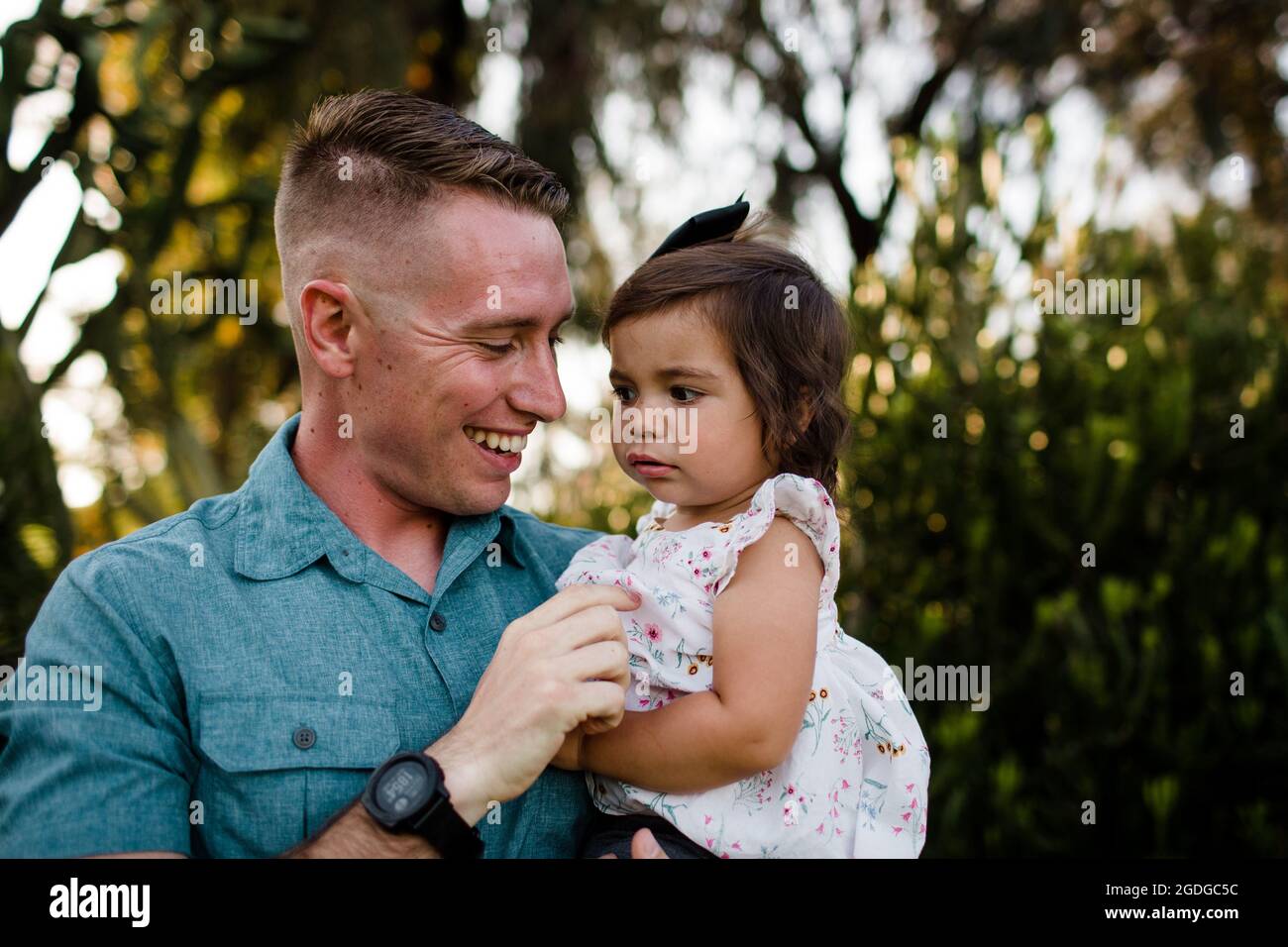 Cerca del Padre Militar sosteniendo a su hija joven en San Diego Foto de stock