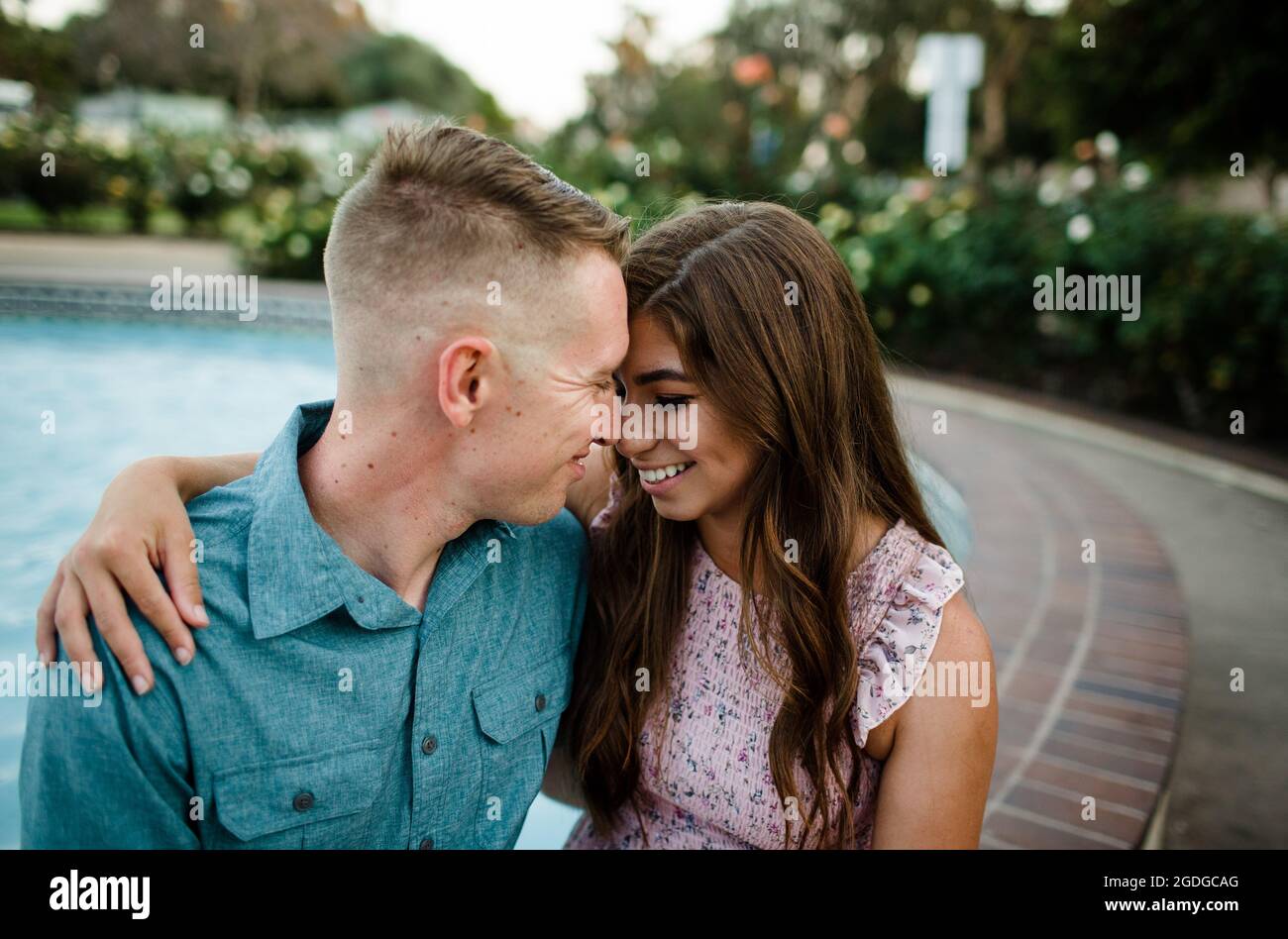 Marido y esposa abrazando al lado de la fuente en San Diego Foto de stock