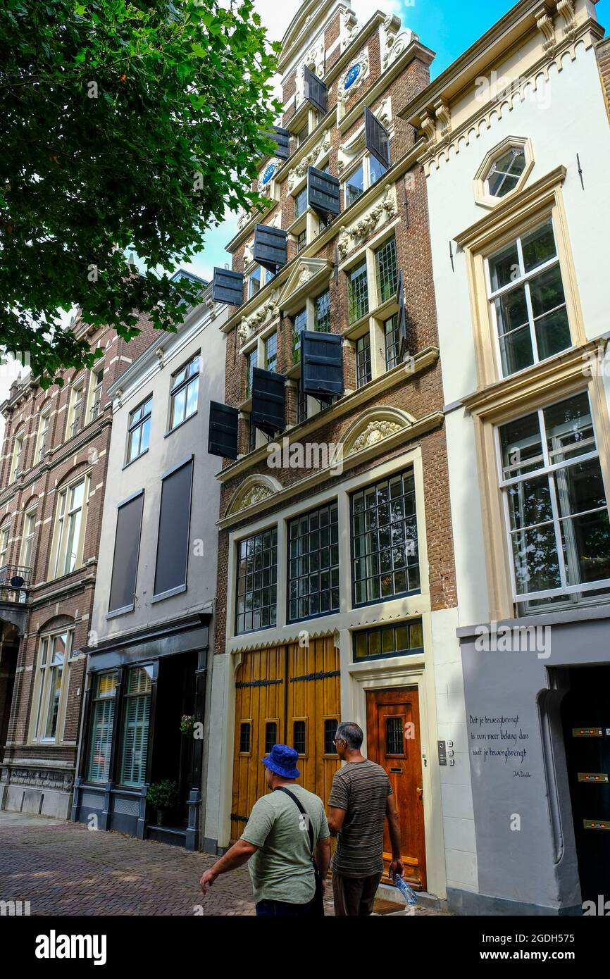 NLD, Niederlande, Overijssel, Deventer, 12.08.2021: zwei Passanten vor der Fassade eines praechtigen alten Handelshauses aus dem Jahr 1659 in der Stra Foto de stock