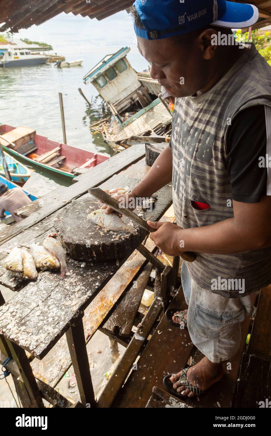 Waisai, Indonesia - 17 de octubre de 2019: Pescaderos que trabajan y limpian los peces que venden en sus puestos en el mercado de Waisai Foto de stock