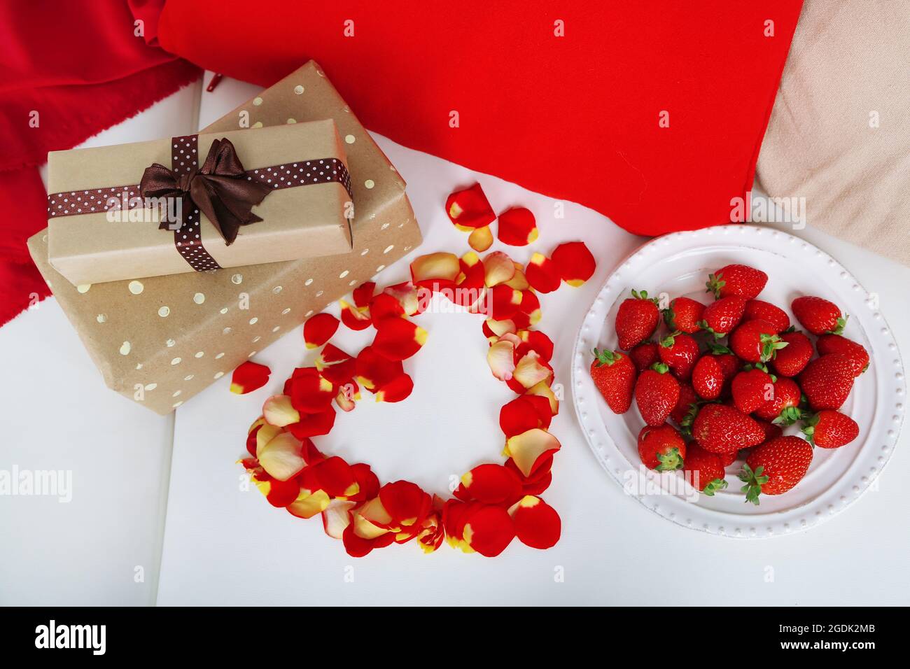 Vida romántica con fresa, regalos y pétalos de rosas en el sofá Fotografía  de stock - Alamy