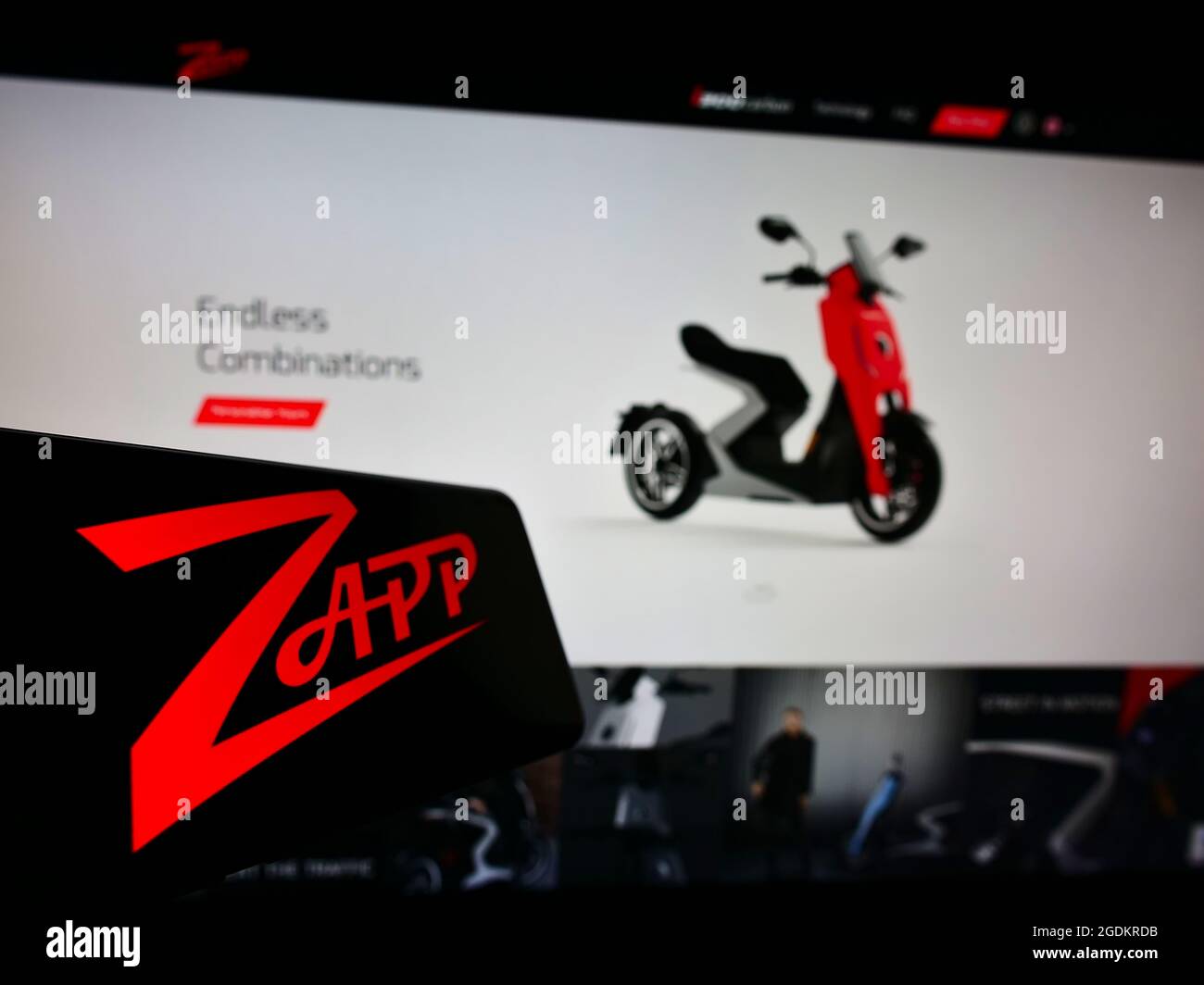 Teléfono móvil con el logotipo de la empresa de motocicletas eléctricas Zapp Scooters Ltd. En la pantalla frente al sitio web de negocios. Enfoque en la parte central izquierda de la pantalla del teléfono. Foto de stock