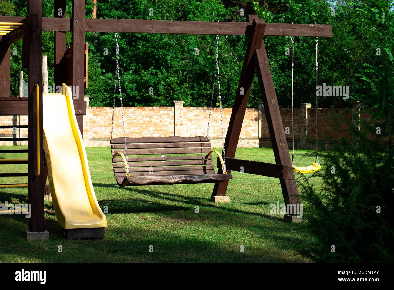 Parque infantil con columpio para bebés y deslice cerca de casas Fotografía  de stock - Alamy
