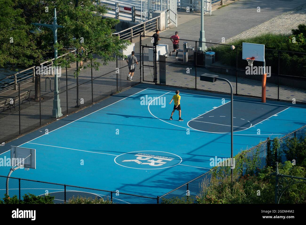 Un joven practicó sus tiros de baloncesto en una cancha en Hudson River  Park. El parque corre por casi cinco millas a lo largo del lado oeste de  Manhattan Fotografía de stock -
