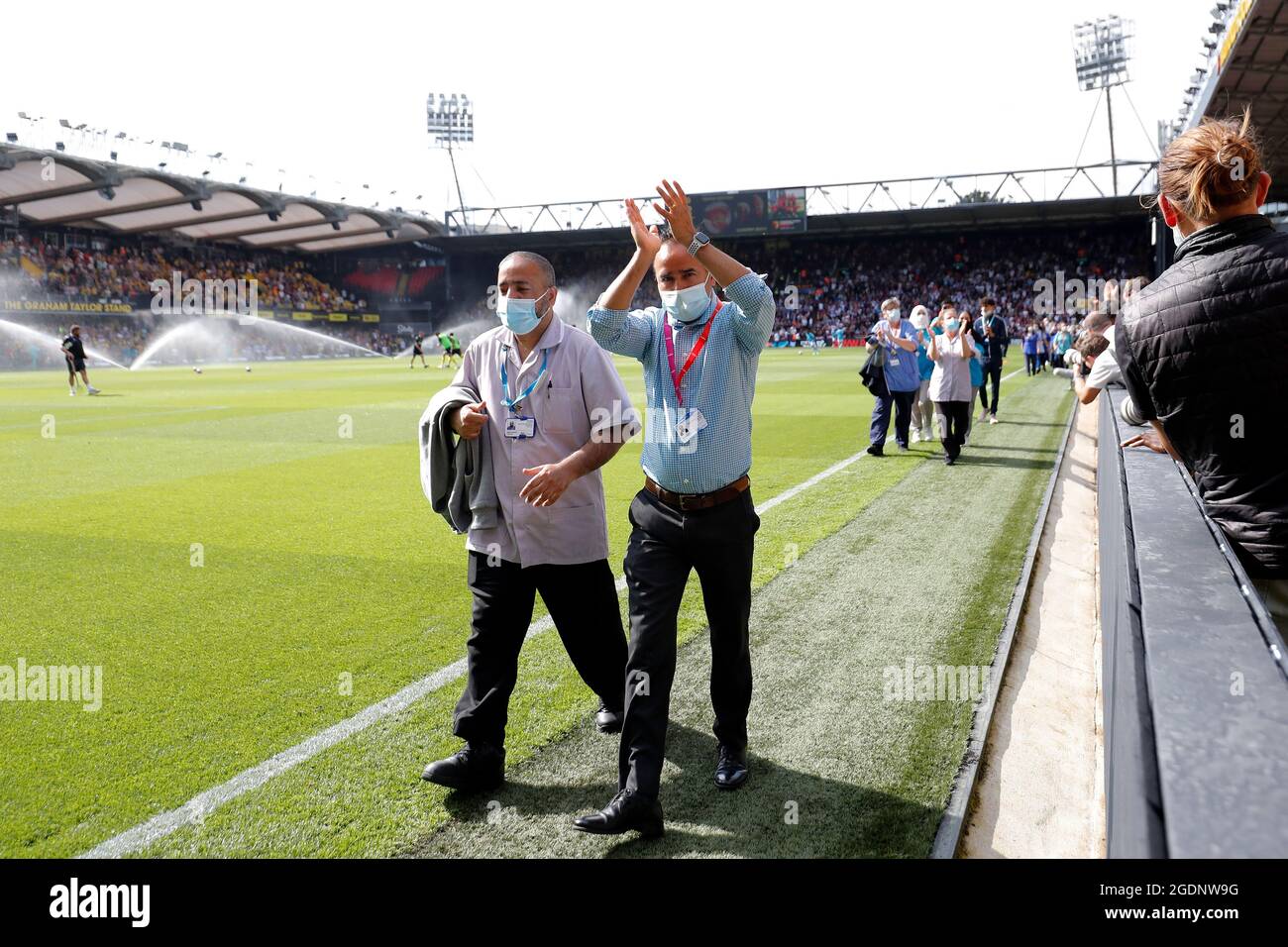 14th de agosto de 2021; Vicarage Road Stadium, Watford, Herts, Inglaterra; Fútbol de la Premier League, Watford versus Aston Villa; personal y voluntarios del Hospital General Watford caminan por un guardia de honor a media hora mientras son aplaudidos por los fans de Watford y Aston Villa por luchar con el Coronavirus Foto de stock