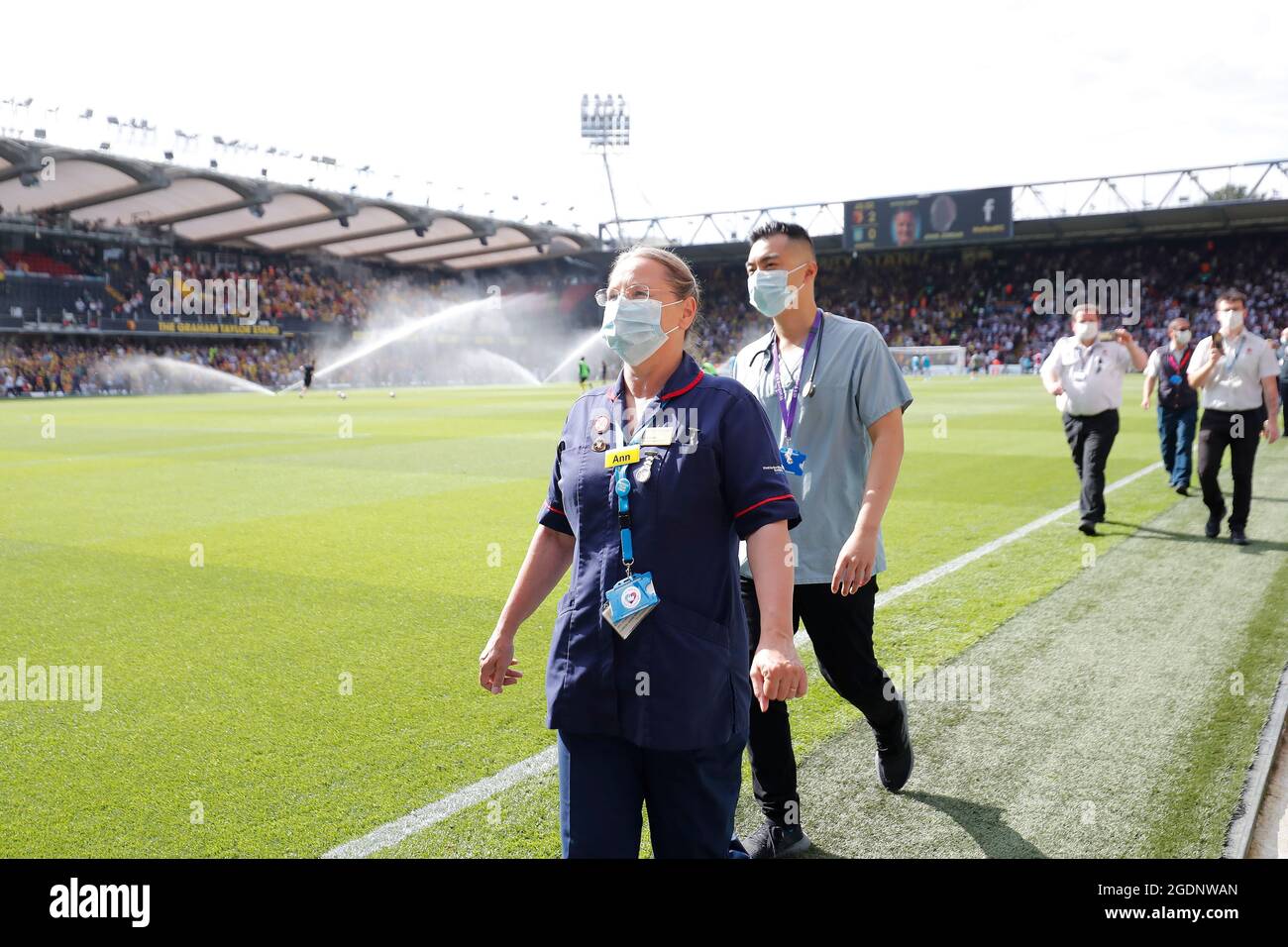 14th de agosto de 2021; Vicarage Road Stadium, Watford, Herts, Inglaterra; Fútbol de la Premier League, Watford versus Aston Villa; personal y voluntarios del Hospital General Watford caminan por un guardia de honor a media hora mientras son aplaudidos por los fans de Watford y Aston Villa por luchar con el Coronavirus Foto de stock