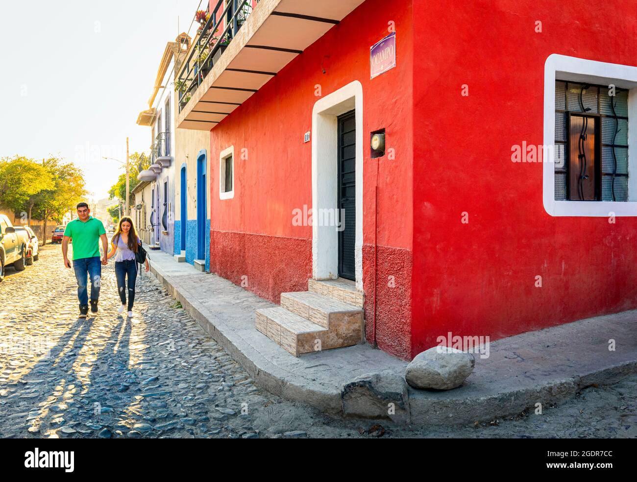 Una joven pareja camina por las coloridas calles de Ajijic, Jalisco, México. Foto de stock