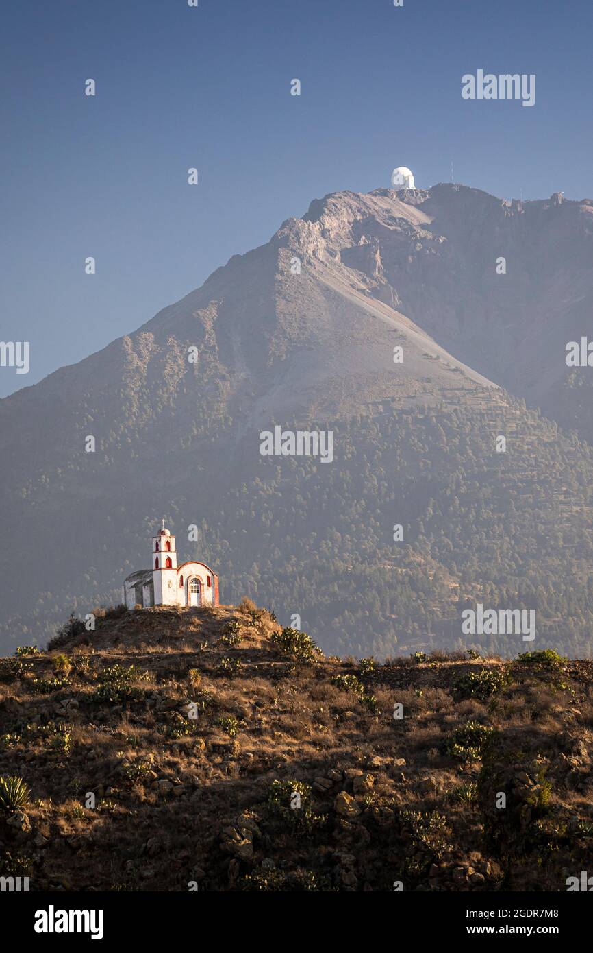Una yuxtaposición de la ciencia y la religión, el Gran Telescopio Milimétrico Alfonso Serrano y una iglesia en la cima de una colina cerca de Atzitzintla, Puebla, México. Foto de stock