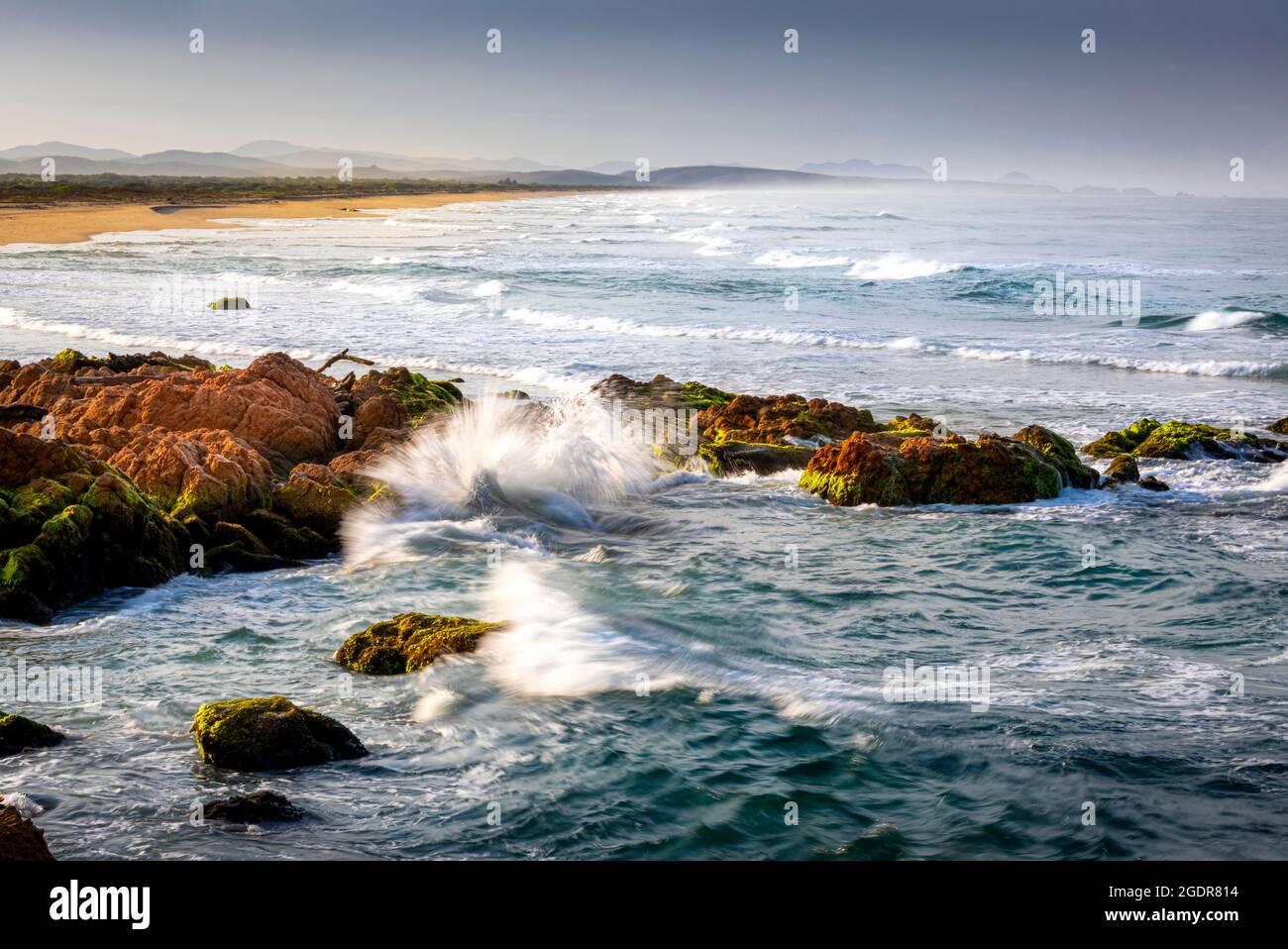 Las olas chocan sobre rocas que miran hacia el norte en la costa del Pacífico en la playa de Chalacatepec en Jalisco, México. Foto de stock