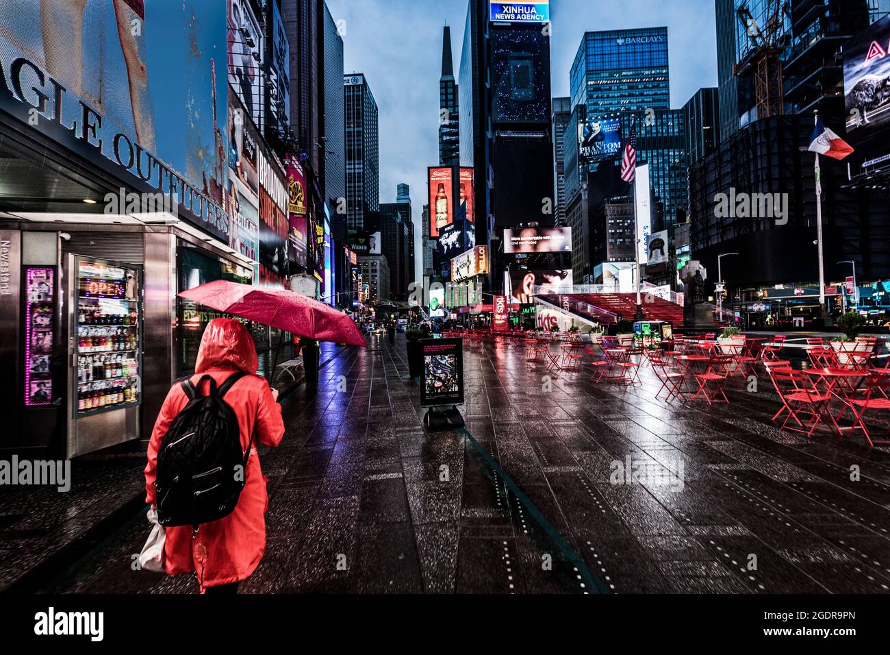 Chica con un paraguas rojo en una mañana lluviosa en Times Square, Nueva York, Estados Unidos. Foto de stock