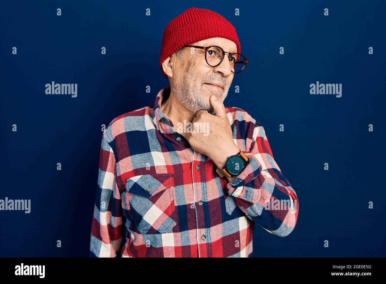 Hombre maduro guapo con look hipster con gorro de lana con mano en la  barbilla pensando en la pregunta, expresión pensativa. Sonriendo con cara  reflexiva. Hacer Fotografía de stock - Alamy